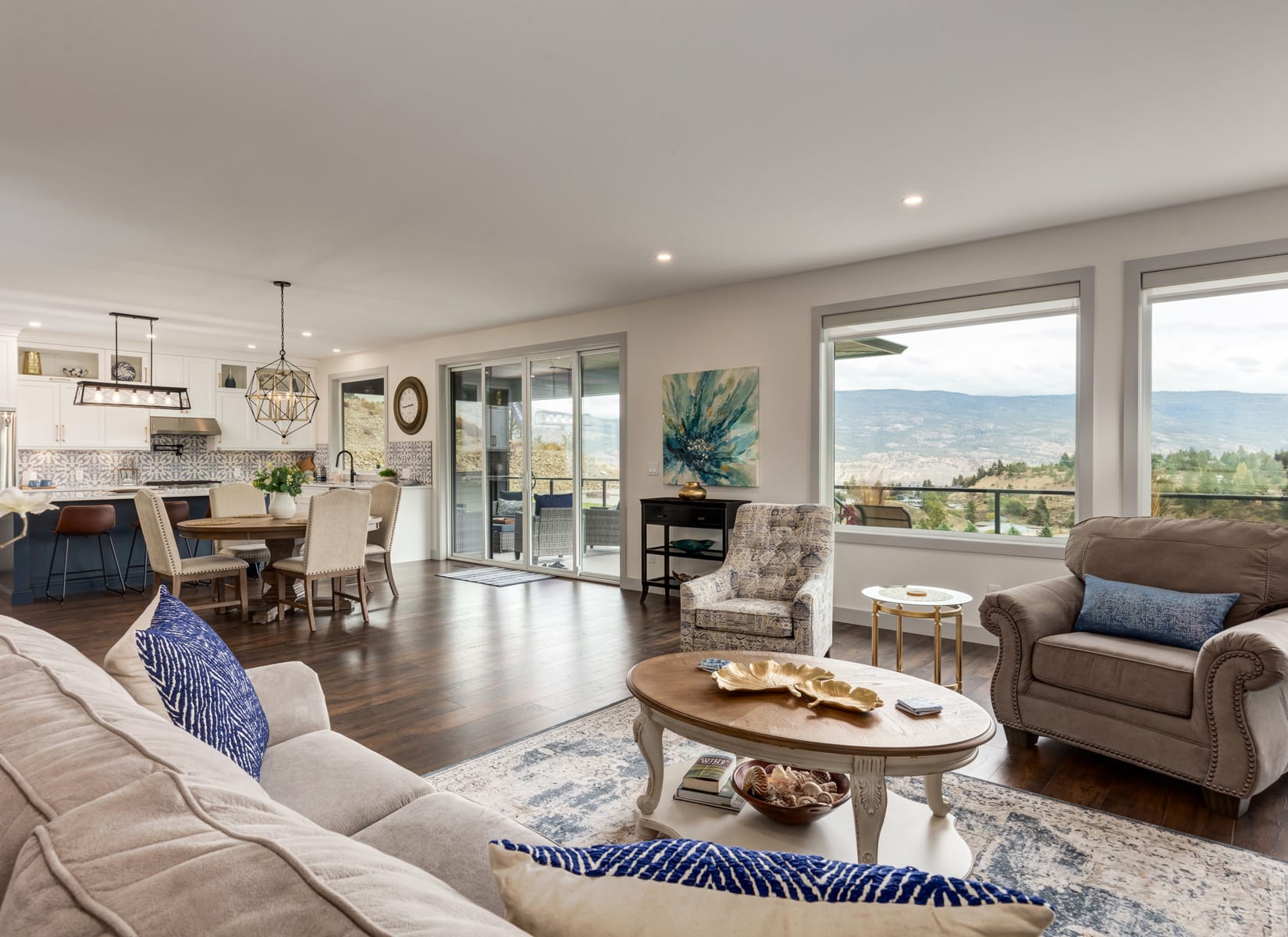 A cozy living room featuring large windows that showcase a stunning view of the mountains in the background.