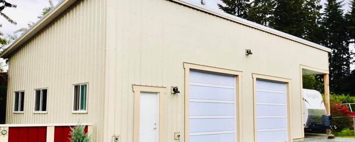 A garage featuring two doors and a red roof, set against a clear blue sky.