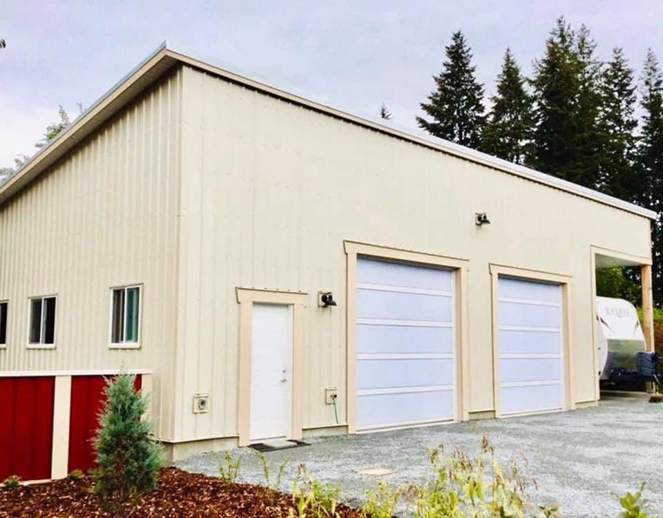 A garage featuring two doors and a red roof, set against a clear blue sky.