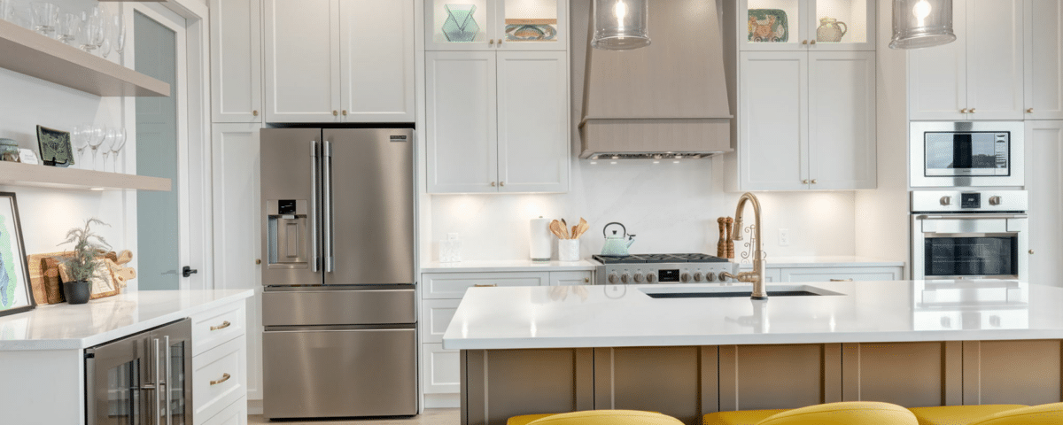 A modern kitchen featuring white cabinets and bright yellow stools, creating a cheerful and inviting atmosphere.