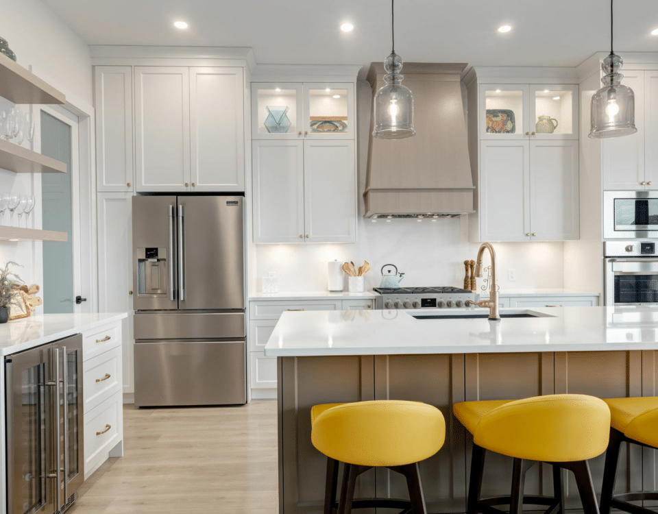 A modern kitchen featuring white cabinets and bright yellow stools, creating a cheerful and inviting atmosphere.
