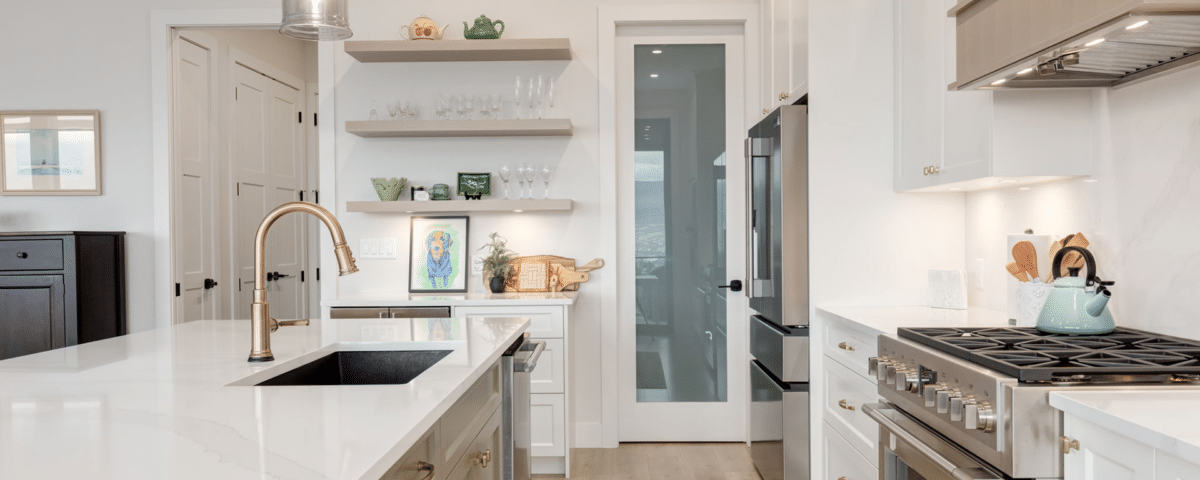 A modern kitchen featuring a white countertop and a sleek stainless steel oven, showcasing a clean and contemporary design.