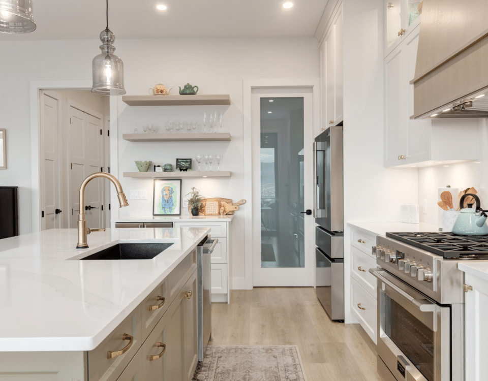 A modern kitchen featuring a white countertop and a sleek stainless steel oven, showcasing a clean and contemporary design.