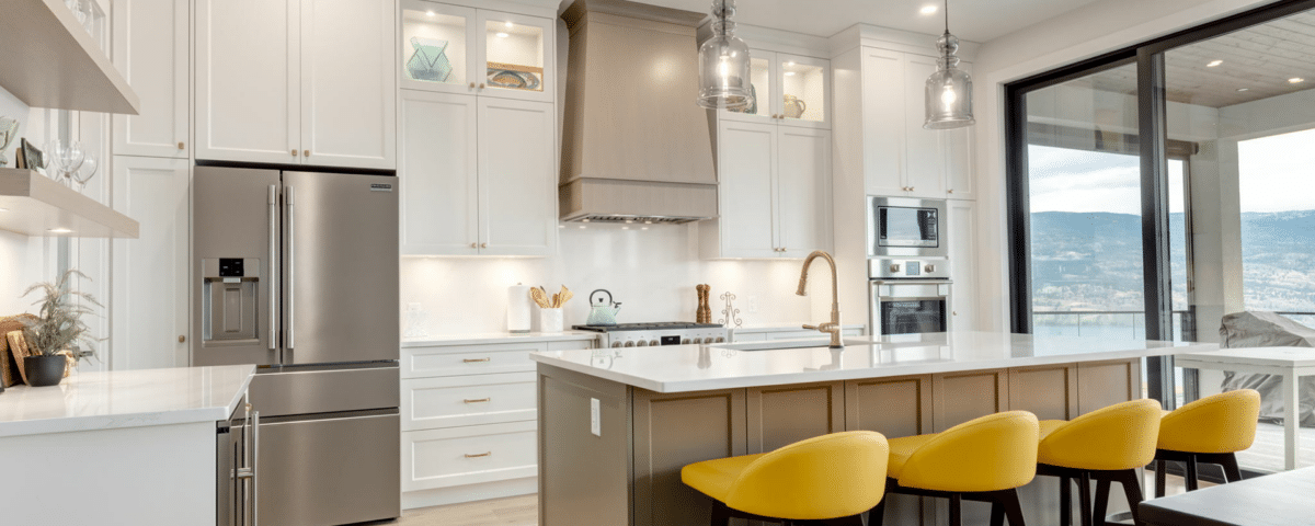 A modern kitchen featuring sleek white cabinets and vibrant yellow stools, creating a bright and inviting atmosphere.