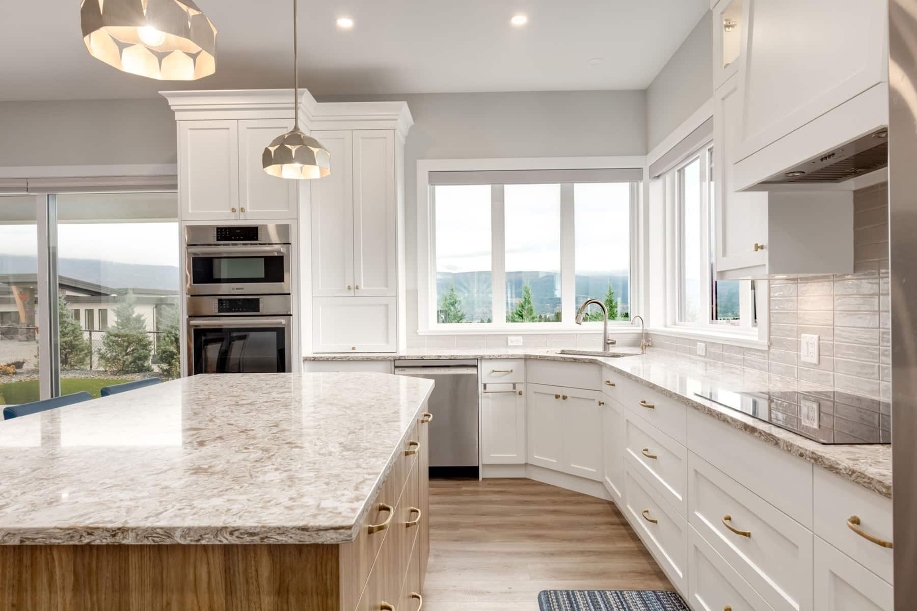 A clean kitchen featuring white cabinets and elegant granite countertops, showcasing a modern and organized space.