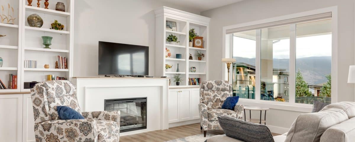 A cozy living room featuring white walls, a warm fireplace, and comfortable seating arrangements.