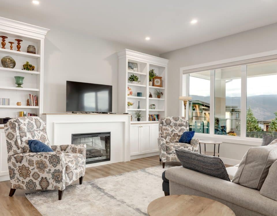 A cozy living room featuring white walls, a warm fireplace, and comfortable seating arrangements.
