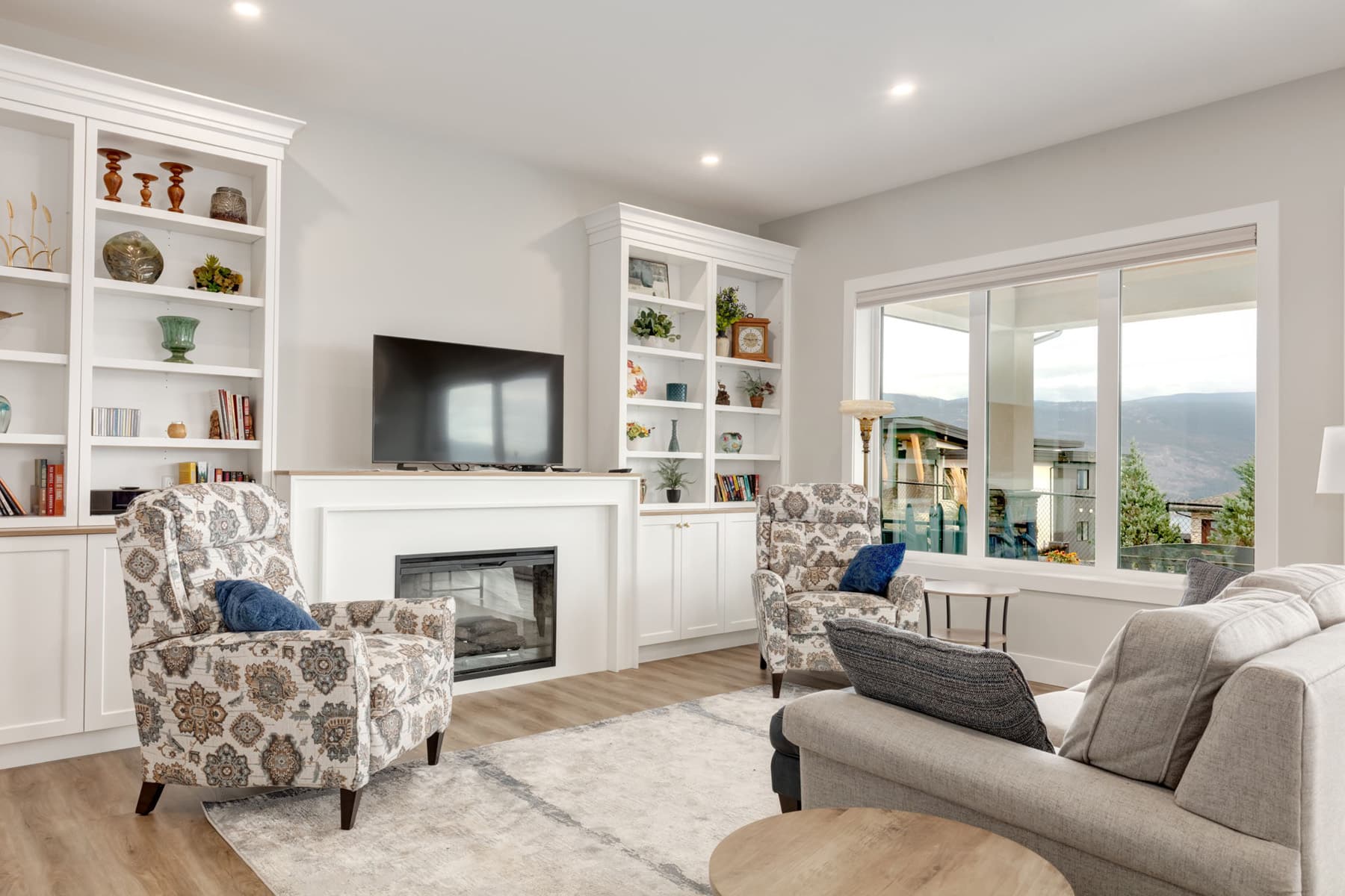 A cozy living room featuring white walls, a warm fireplace, and comfortable seating arrangements.