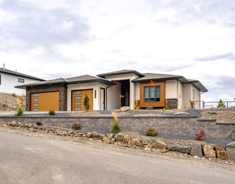 A mountain home featuring a driveway and garage, surrounded by scenic views of the mountains.