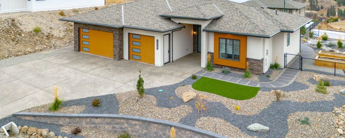 A spacious home featuring a large driveway and well-maintained landscaping, showcasing a welcoming outdoor environment.