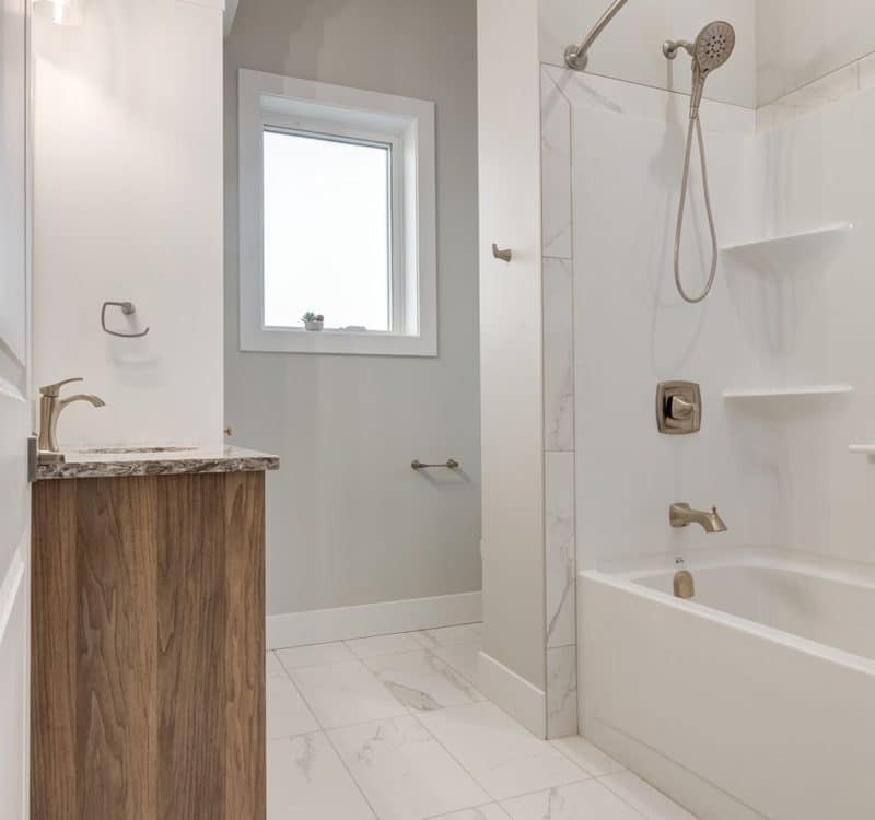 A bathroom featuring a bathtub, a shower, and a toilet, showcasing a clean and modern design.