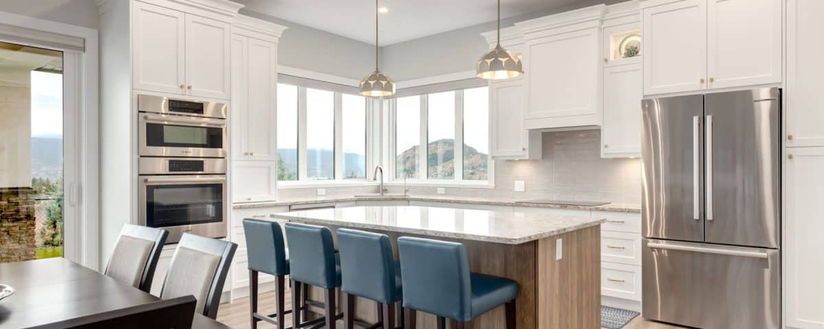 A modern kitchen featuring a central island and sleek stainless steel appliances, showcasing a clean and functional design.